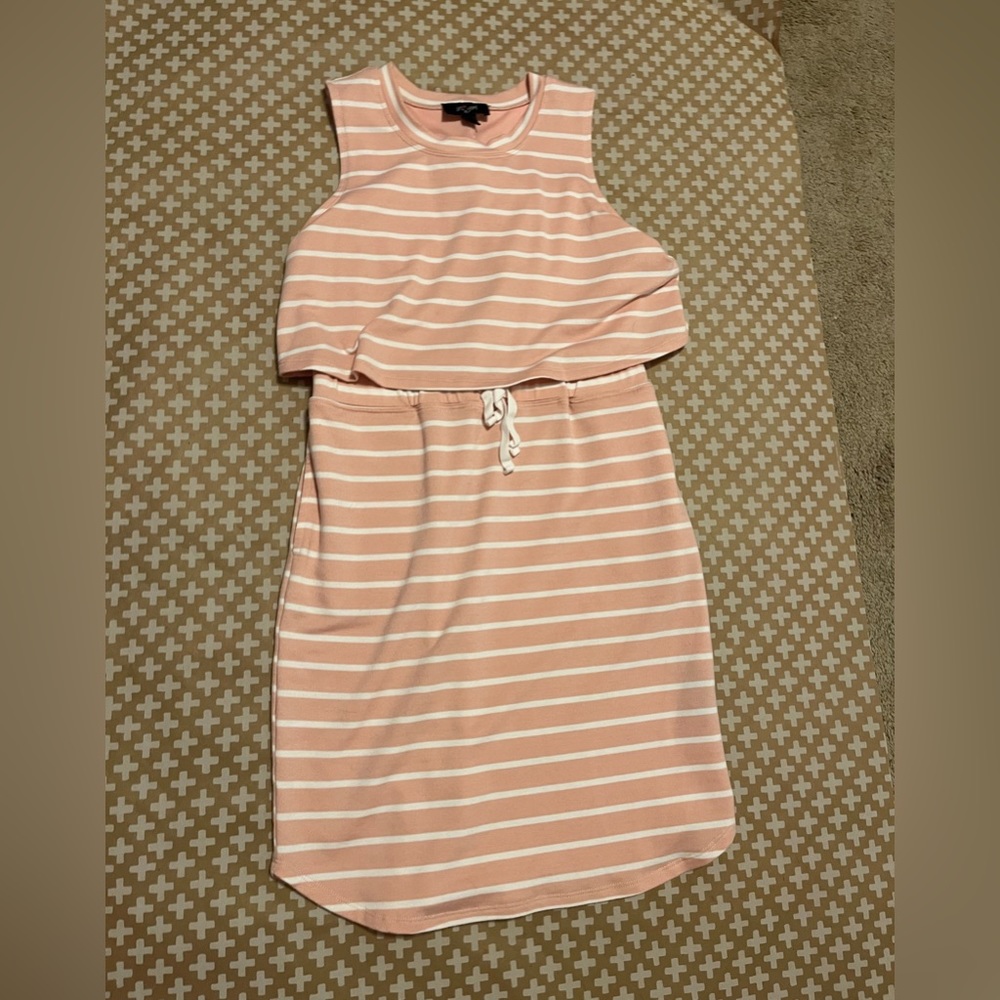 In girl coral pink dress with white stripes and tie at waistline